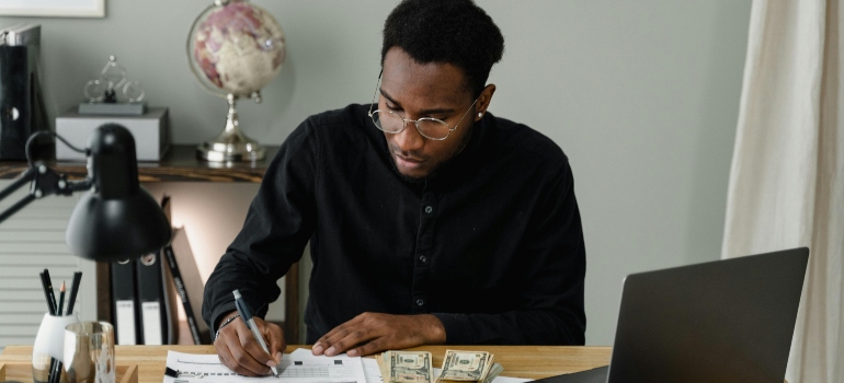 Man reviewing expenses and planning budget for what to consider when moving office locations.